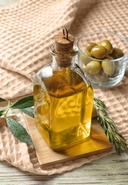 Bottle with fresh olive oil on table