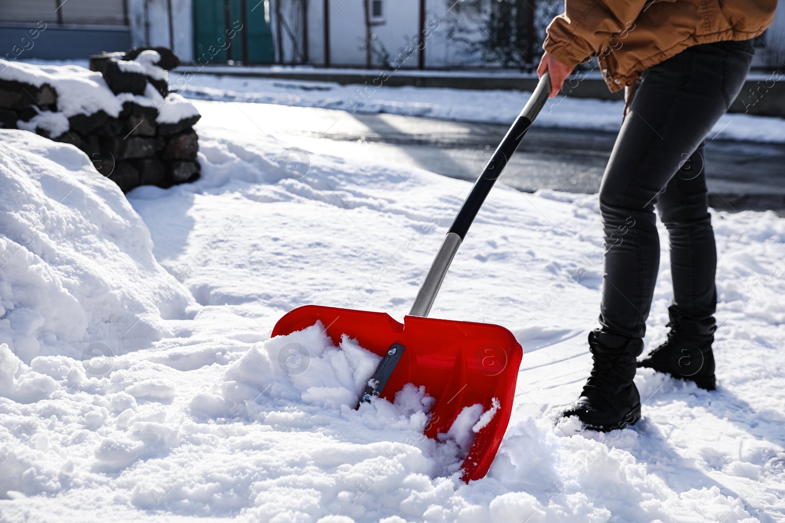 Photo of Person shoveling snow outdoors on winter day, closeup