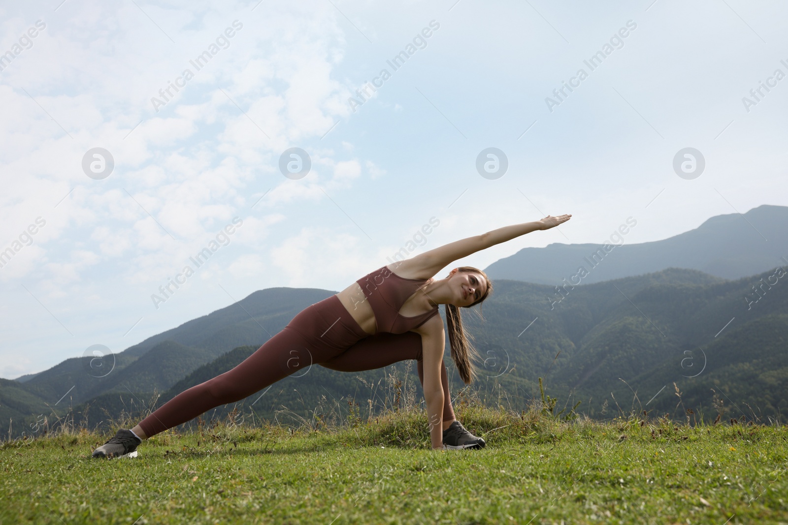 Photo of Young woman doing morning exercise in mountains