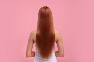 Woman with healthy hair after treatment on pink background, back view