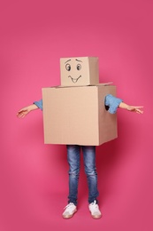 Photo of Cute little child in cardboard costume on color background