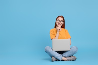 Photo of Smiling young woman with laptop on light blue background, space for text