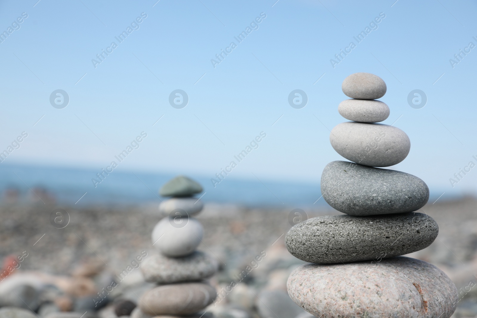 Photo of Stack of stones on beach against blurred background, closeup. Space for text