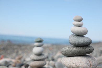 Stack of stones on beach against blurred background, closeup. Space for text