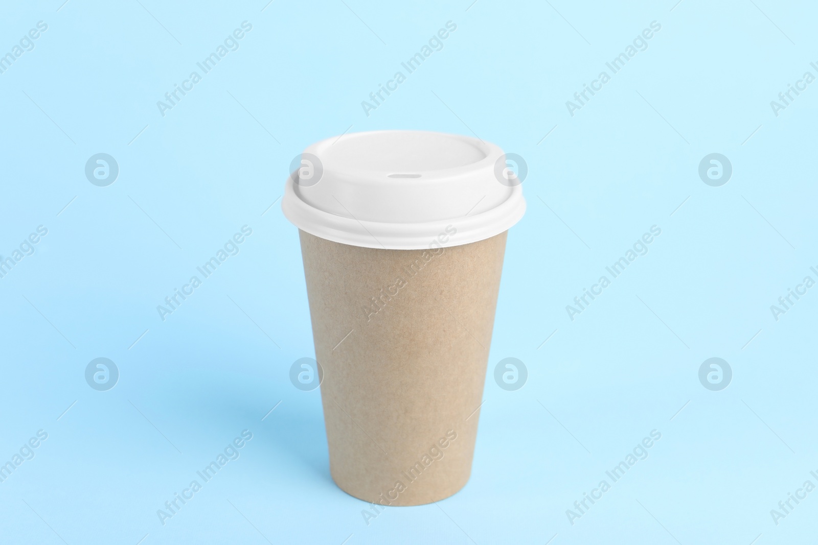 Photo of Paper cup with plastic lid on light blue background. Coffee to go