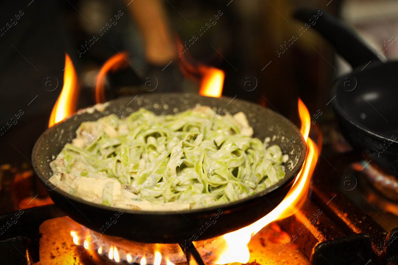 Photo of Cooking delicious noodles with melted cheese on frying pan