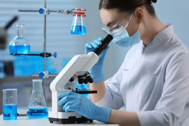 Photo of Young scientist working with microscope in laboratory