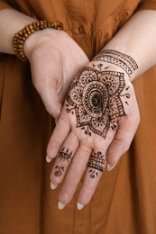 Woman with beautiful henna tattoo on hand, closeup. Traditional mehndi