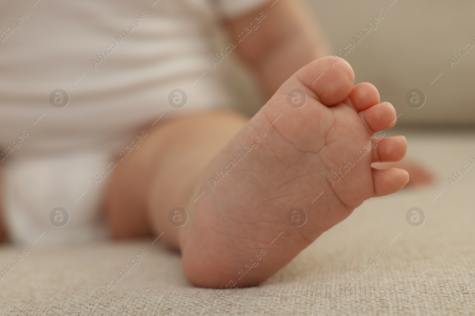 Photo of Little baby on sofa at home, closeup