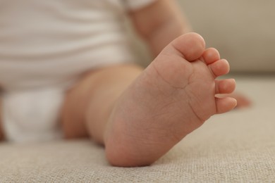 Photo of Little baby on sofa at home, closeup