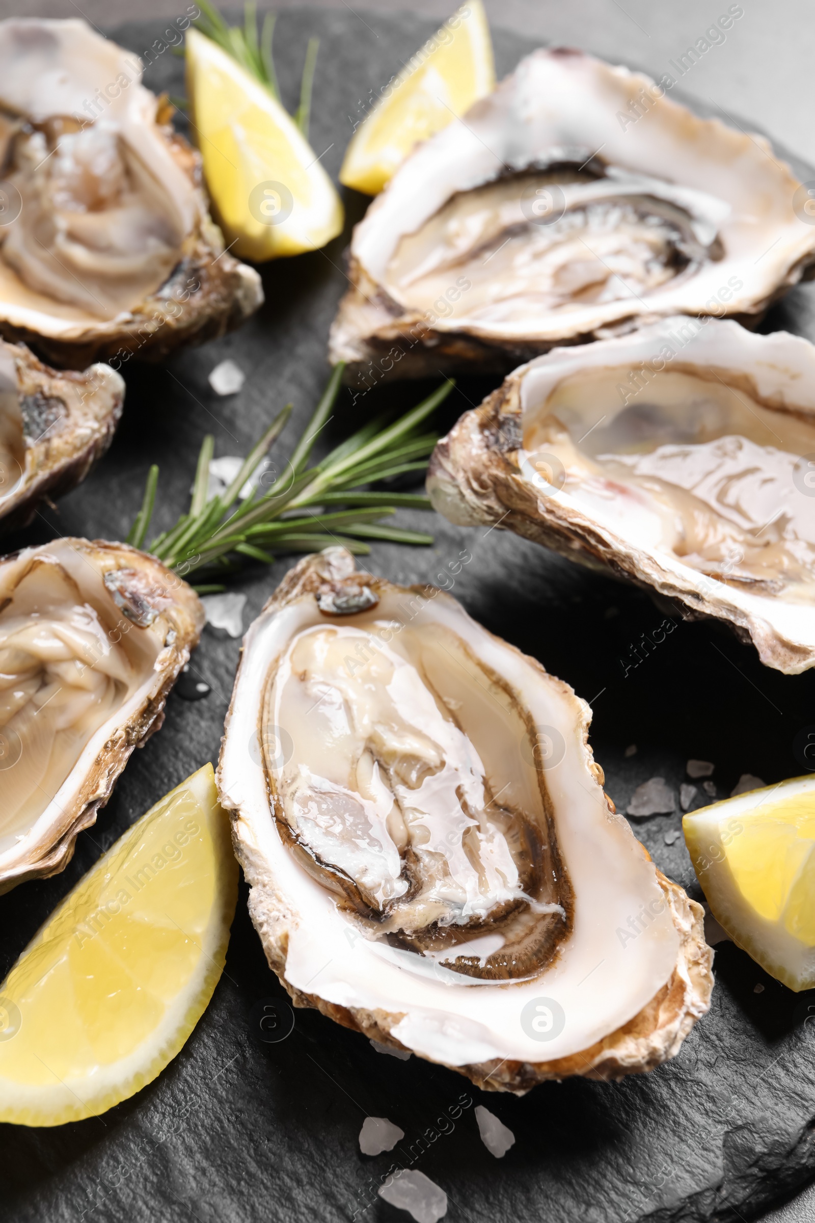 Photo of Delicious fresh oysters with lemon slices served on table