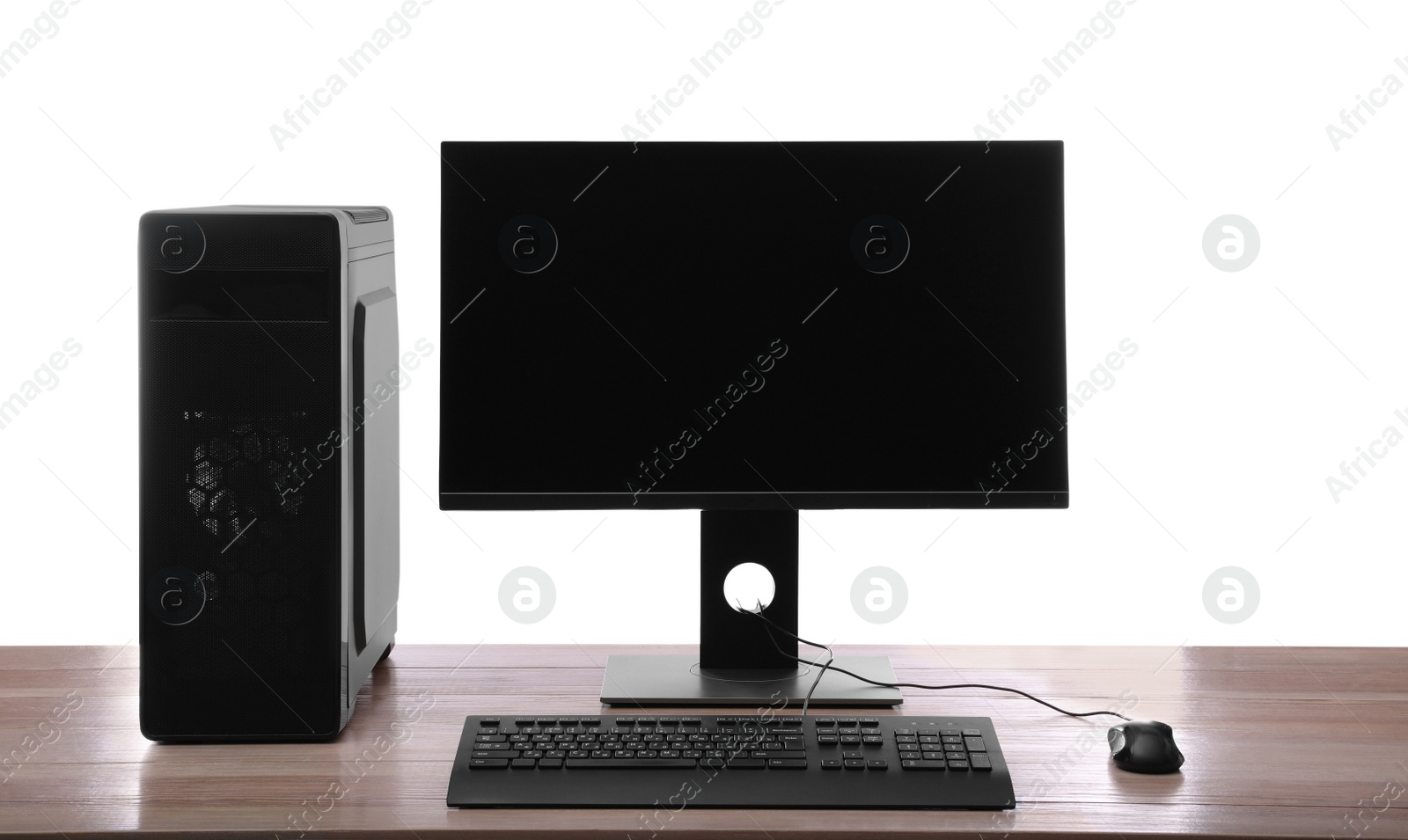 Photo of Modern computer with blank monitor screen and peripherals on wooden table against white background