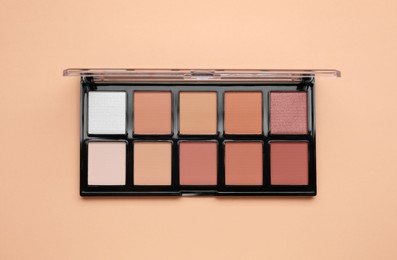 Colorful contouring palette on beige background, top view. Professional cosmetic product