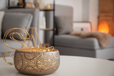 Vase with garland on table in living room. Interior design element