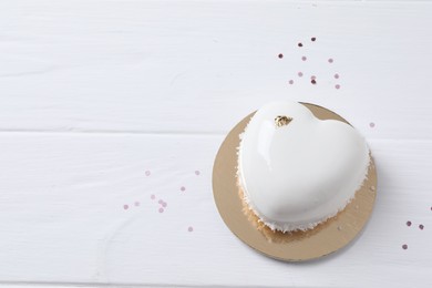 Photo of St. Valentine's Day. Delicious heart shaped cake and confetti on white wooden table, top view. Space for text