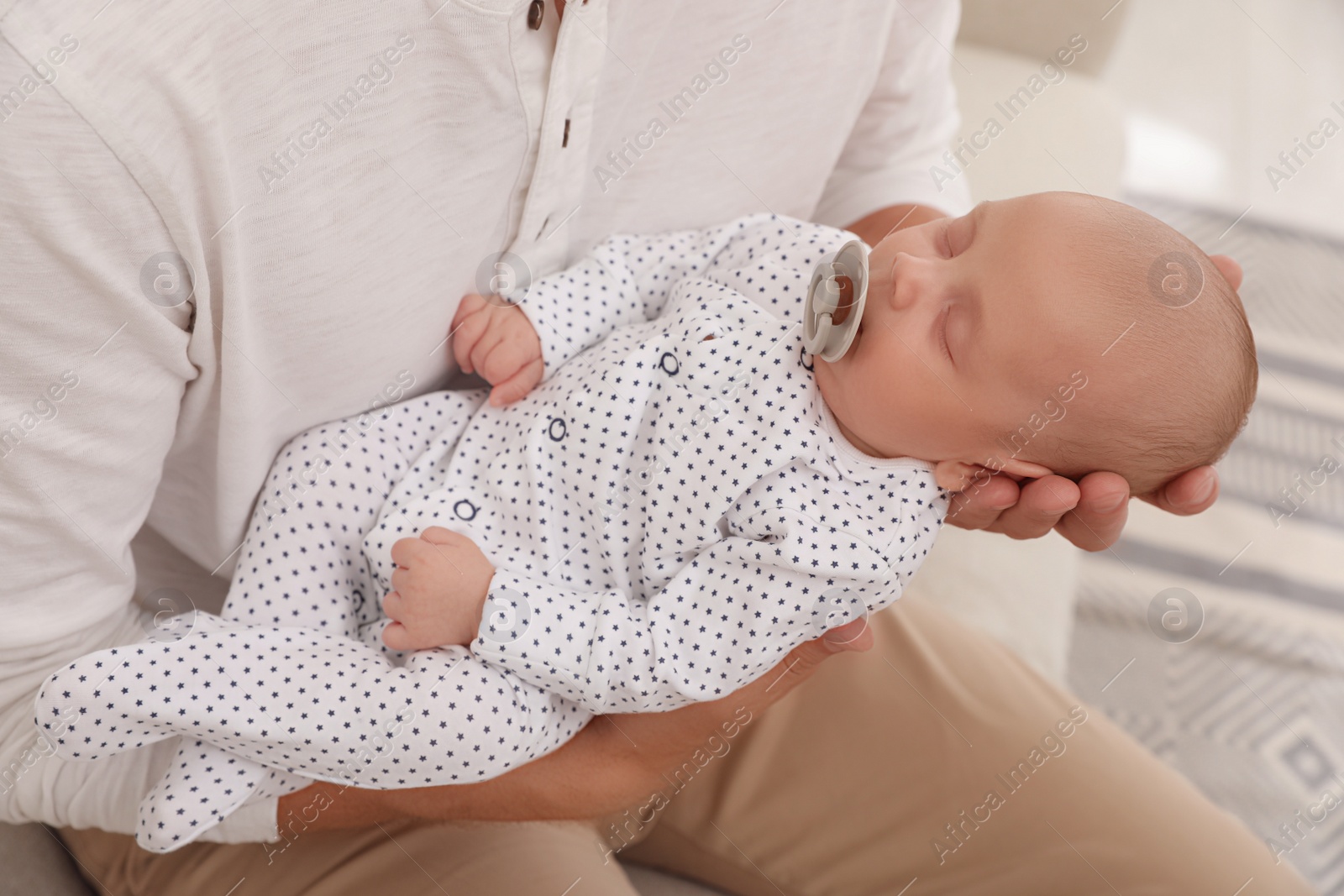 Photo of Father with his cute sleeping baby at home, closeup