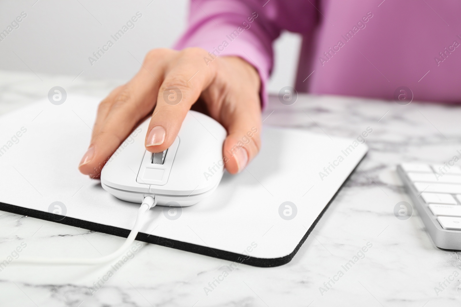 Photo of Woman using modern wired optical mouse at office table, closeup