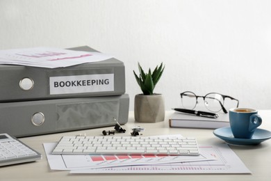 Photo of Bookkeeper's workplace with folders and documents on table