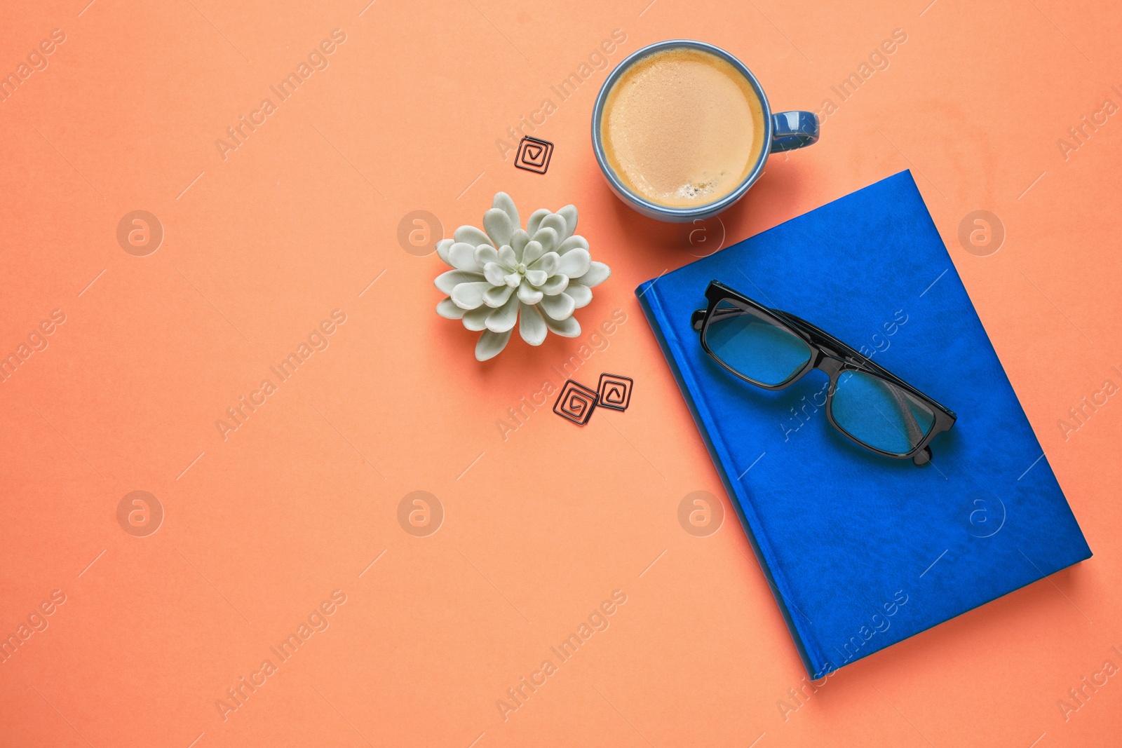 Photo of Flat lay composition inspired by color of the year 2020  (Classic blue) on orange background. Space for text