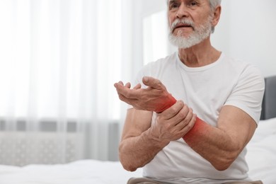 Image of Senior man suffering from pain in arm indoors, closeup. Space for text