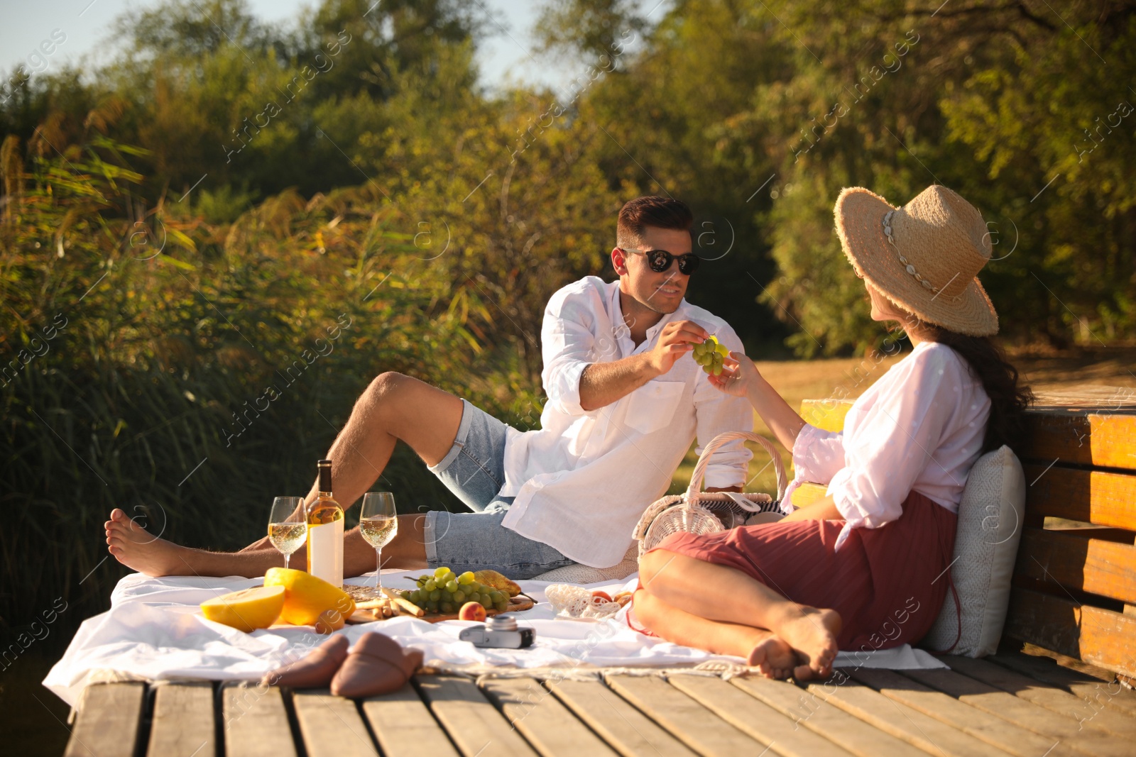 Photo of Happy couple spending time on pier at picnic