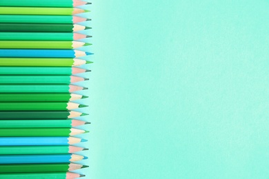 Photo of Different pencils on mint color background