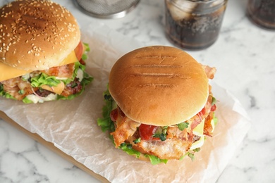 Tasty burgers with bacon served on table