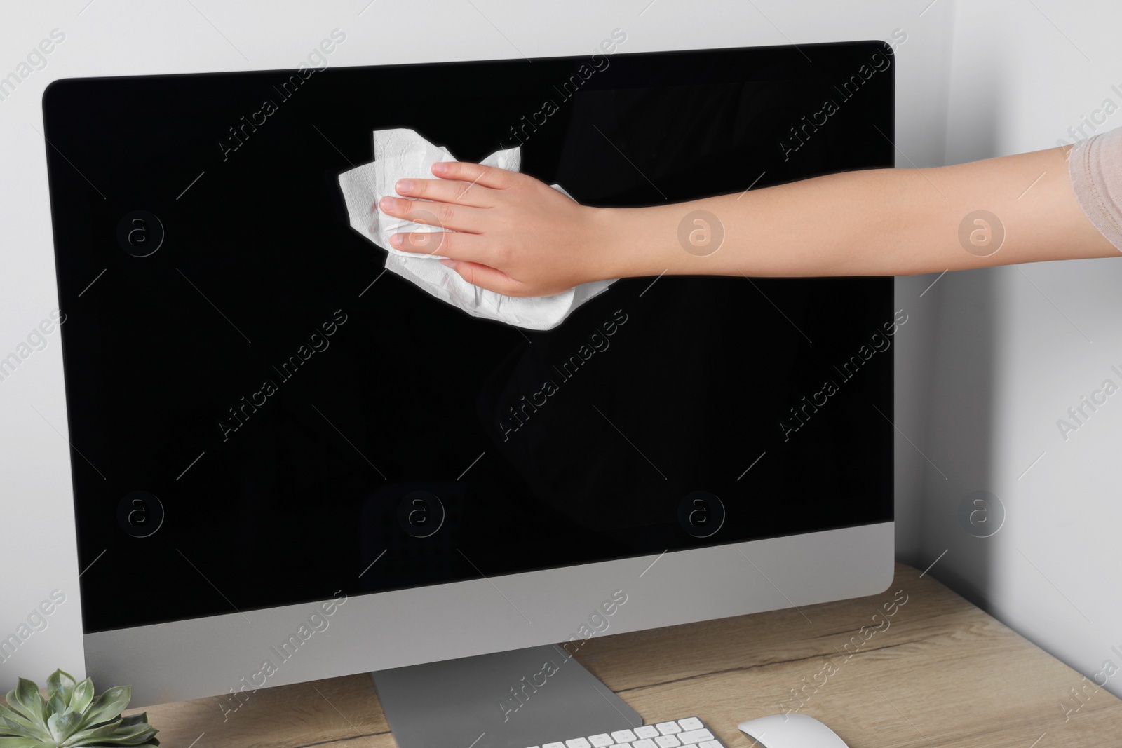 Photo of Woman wiping screen with paper towel, closeup