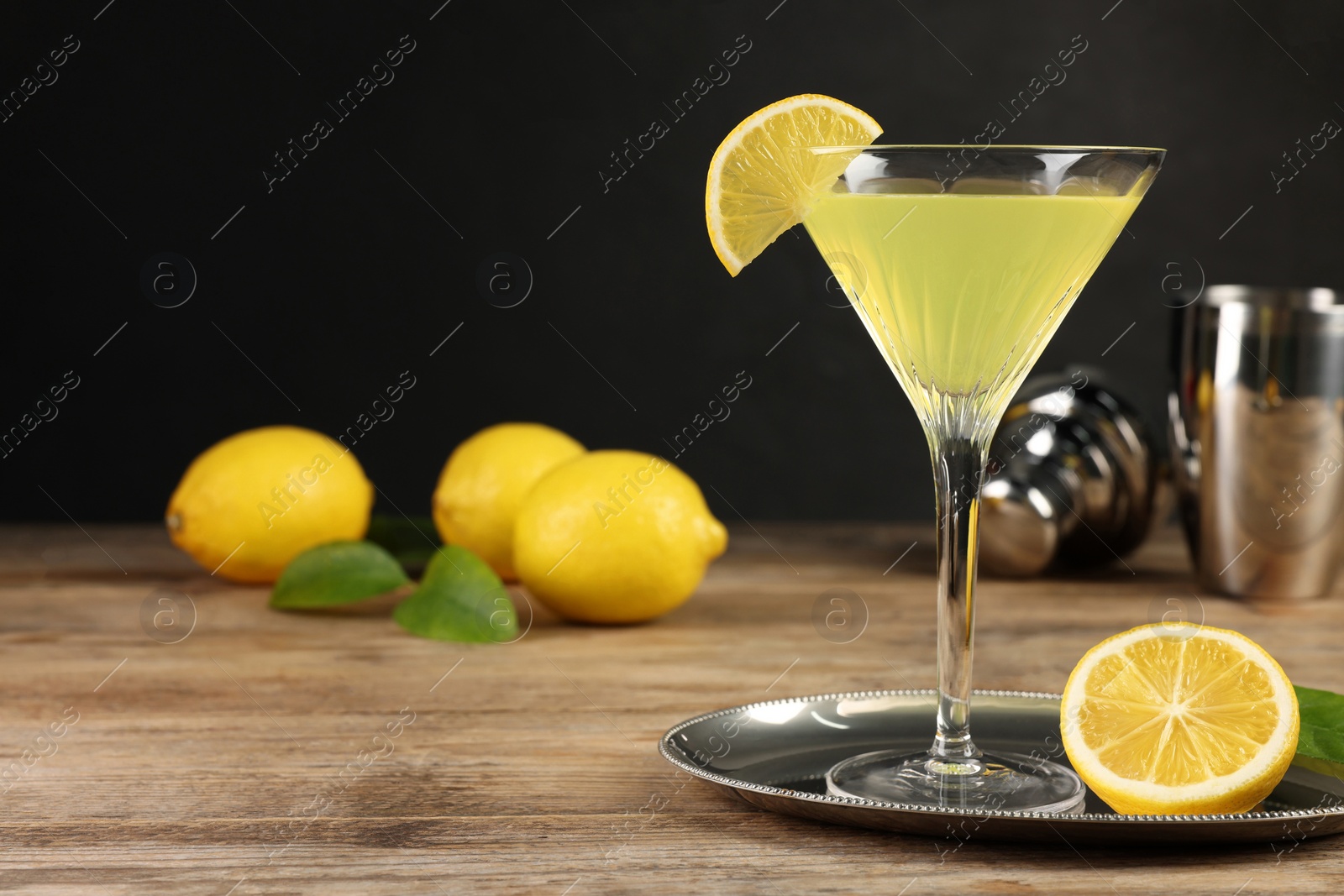 Photo of Lemon Martini cocktail and fresh fruits on wooden table, space for text