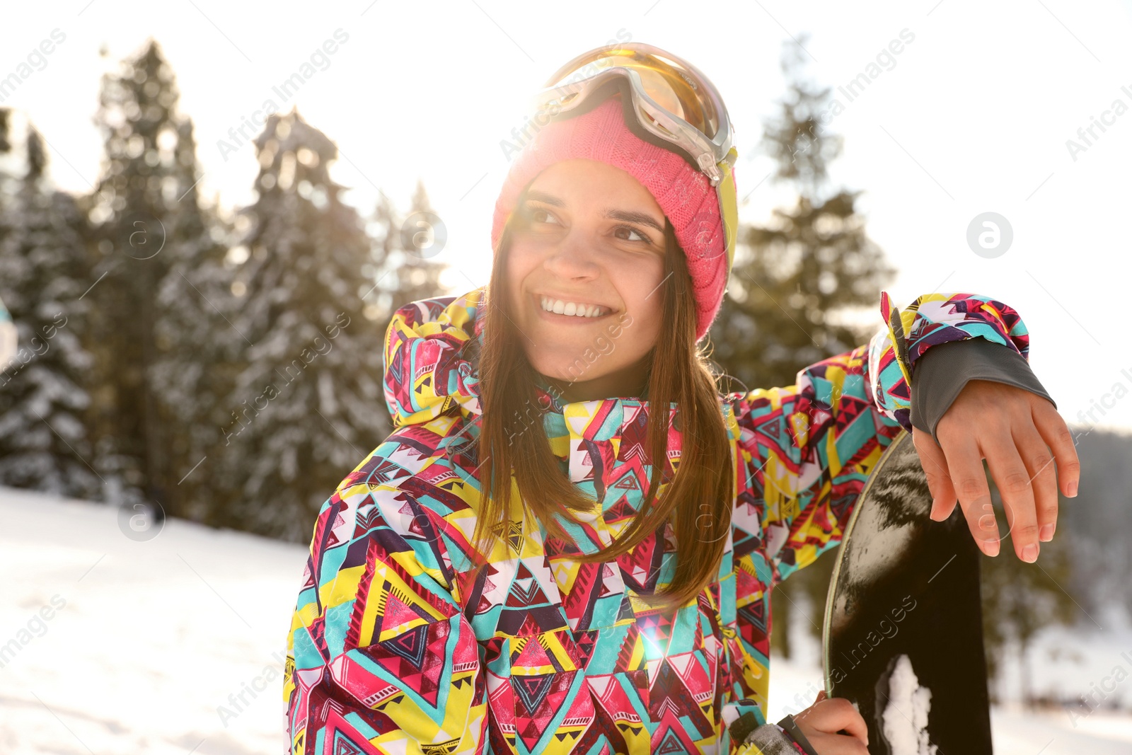Photo of Young woman with snowboard on snowy hill. Winter vacation