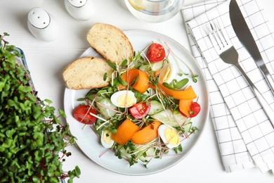 Photo of Salad with fresh organic microgreen in plate on white table, flat lay