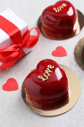 Photo of St. Valentine's Day. Delicious heart shaped cakes and gift on light table, closeup
