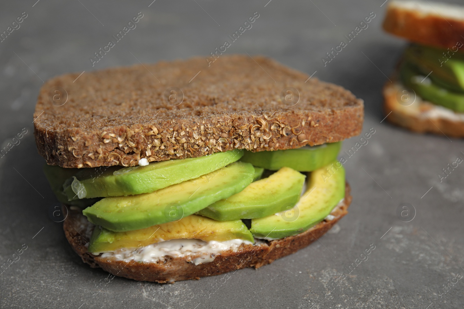 Photo of Tasty avocado sandwich on grey table, closeup