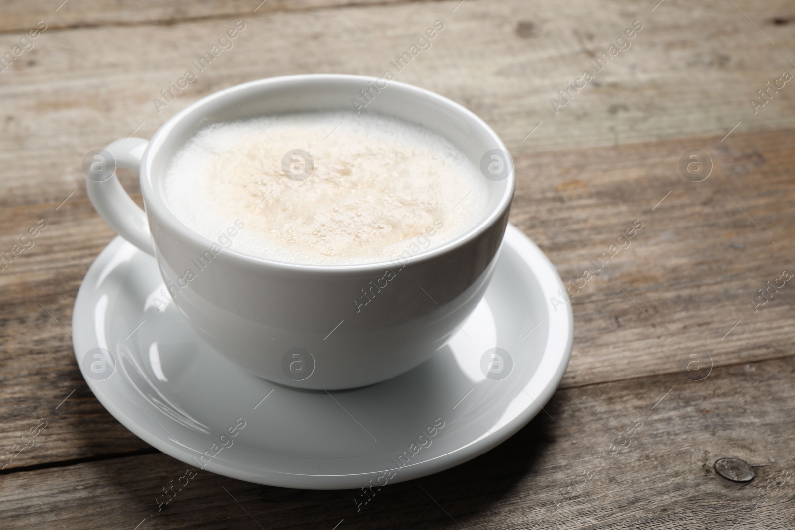 Photo of Aromatic coffee in cup on wooden table. Space for text