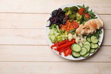 Photo of Balanced diet and healthy foods. Plate with different delicious products on wooden table, top view. Space for text