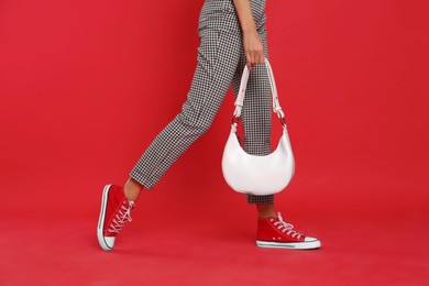 Photo of Woman with stylish bag on red background, closeup