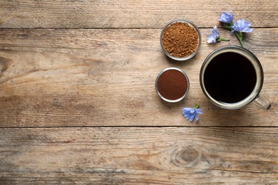 Cup of delicious chicory drink, flowers, granules and powder on wooden table, flat lay. Space for text