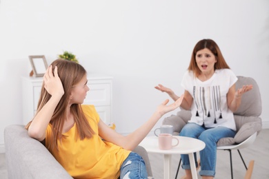 Photo of Mother scolding her teenager daughter at home