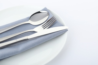 Photo of Plate with cutlery and napkin on white background, closeup