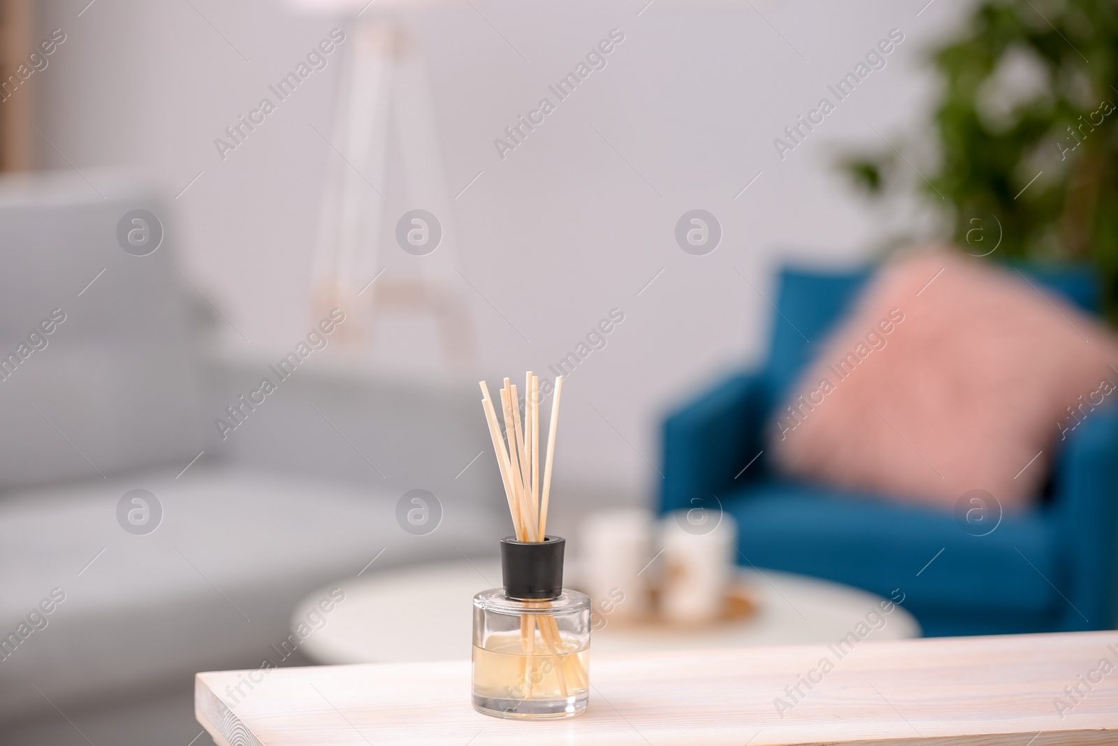 Photo of Handmade reed freshener on table against blurred background