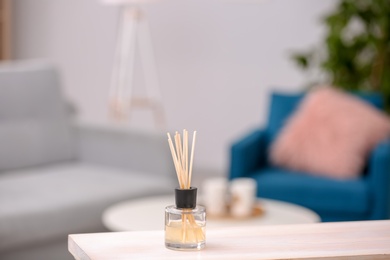 Handmade reed freshener on table against blurred background