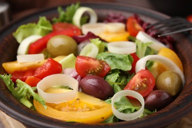 Photo of Bowl of tasty salad with leek and olives on table, closeup