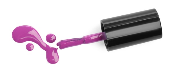 Photo of Brush and spilled purple nail polish isolated on white, top view