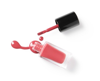 Photo of Spilled color nail polish with bottle and brush on white background, top view