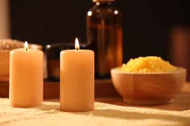 Photo of Spa composition with burning candles and personal care products on soft light surface, closeup