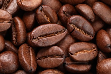 Aromatic roasted coffee beans as background, top view