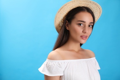 Portrait of beautiful young woman on light blue background