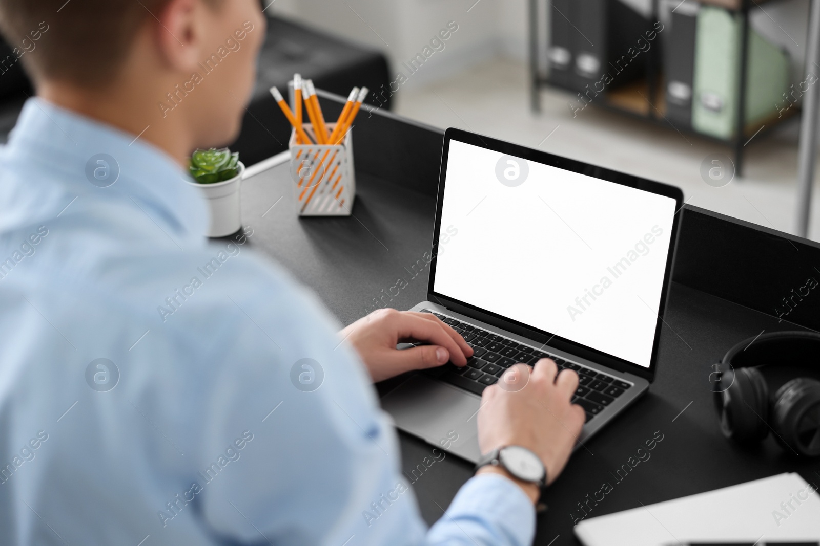 Photo of Man watching webinar at table in office, closeup