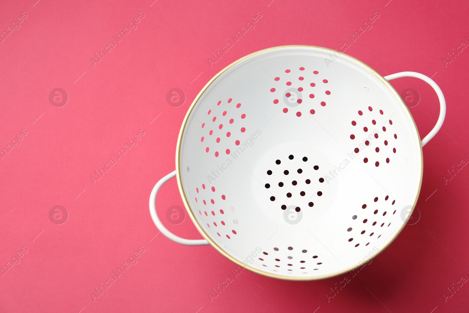 Photo of One clean empty colander on pink table, top view. Space for text