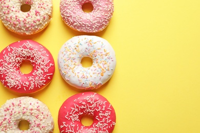 Delicious glazed doughnuts on color background, top view